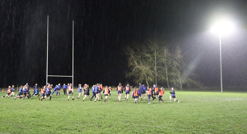 Girls' team playing rugby at night at Keyworth Rugby Club